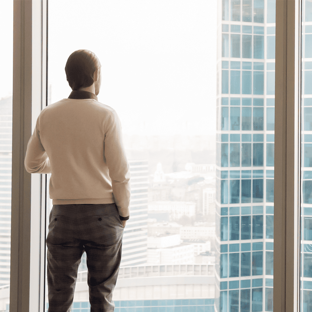 A man reflects on TFA’s private offer as he gazes out from a high-rise office window