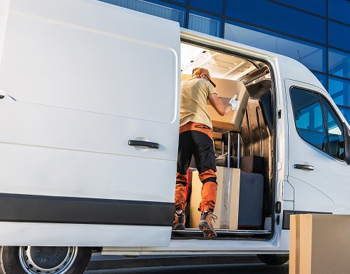 A man loads boxes into a white van, reflecting asset finance support for logistics, transportation, and business equipment needs